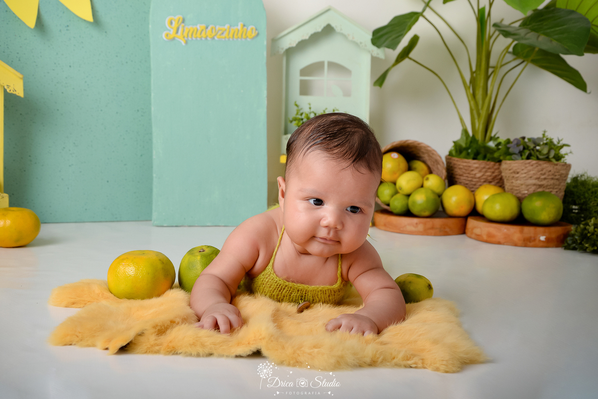 drica studio - ensaio fotográfico infantil - cenário de frutas cítricas - bebê de bruços em tapete felpudo - fundo verde erva-doce - xinguara