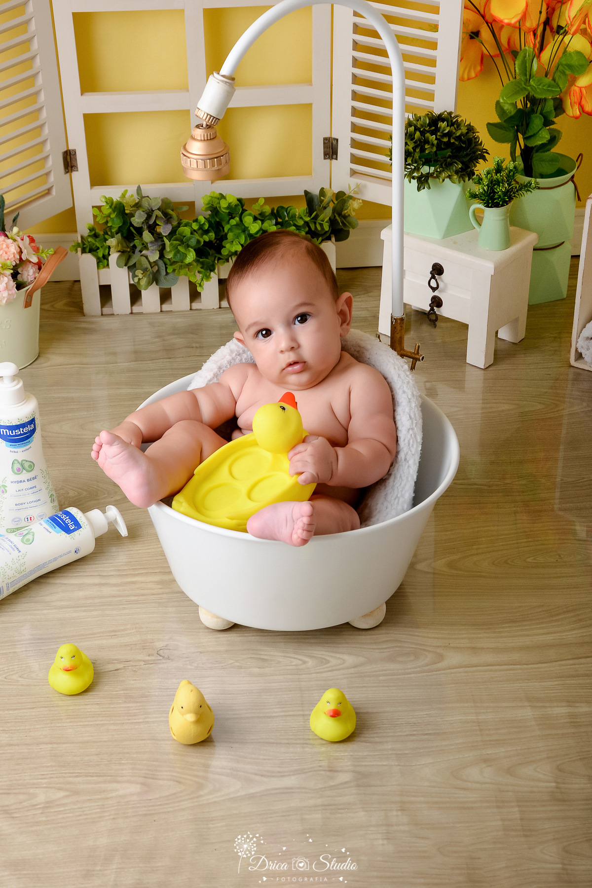 drica studio - ensaio fotográfico - xinguara - bebê dentro de banheira brincando com patinho amarelo de borracha - cômoda pequena branca - piso amadeirado