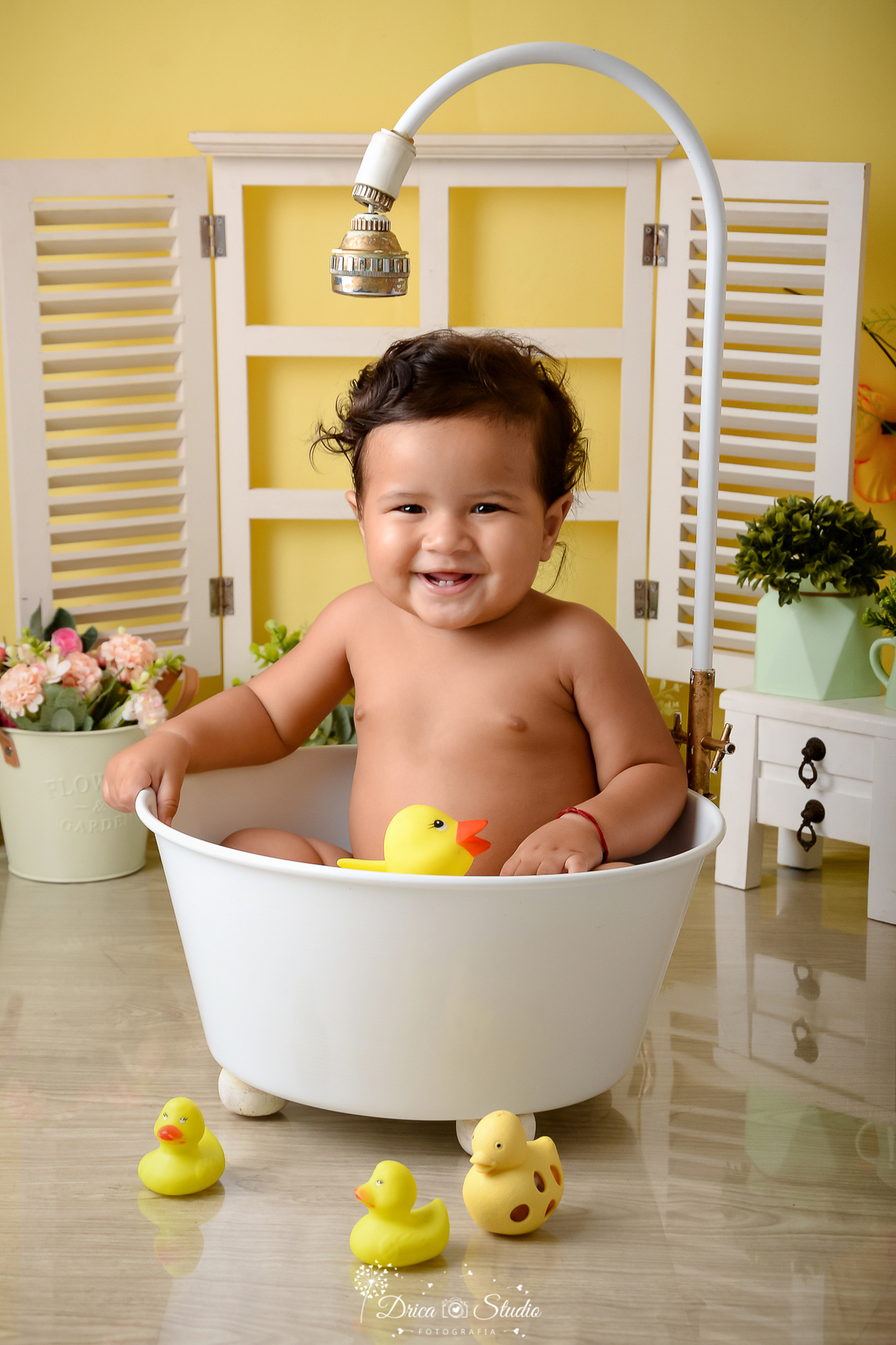 drica studio - ensaio fotográfico - xinguara - menino brincando com patinho amarelo dentro de banheira branca - janela branca - cômoda branca com basos verdes
