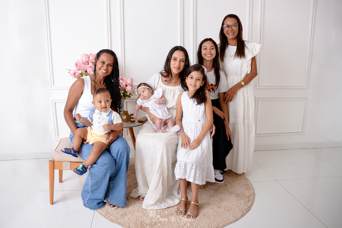 drica studio, ensaio fotografico, xinguara, dia das mães, foto em família avó, fillha e netos, vestindo branco, calça preta, calça jeans, fundo branco com boiserie, tapete redondo berge, flores rosa