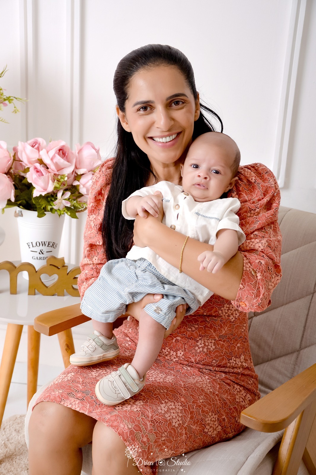 drica studio, ensaio fotografico, xinguara, dia das mães, avó segurando neto no colo, camisa branca, short cinza, flores rosa, vaso branco, poltrona cinza