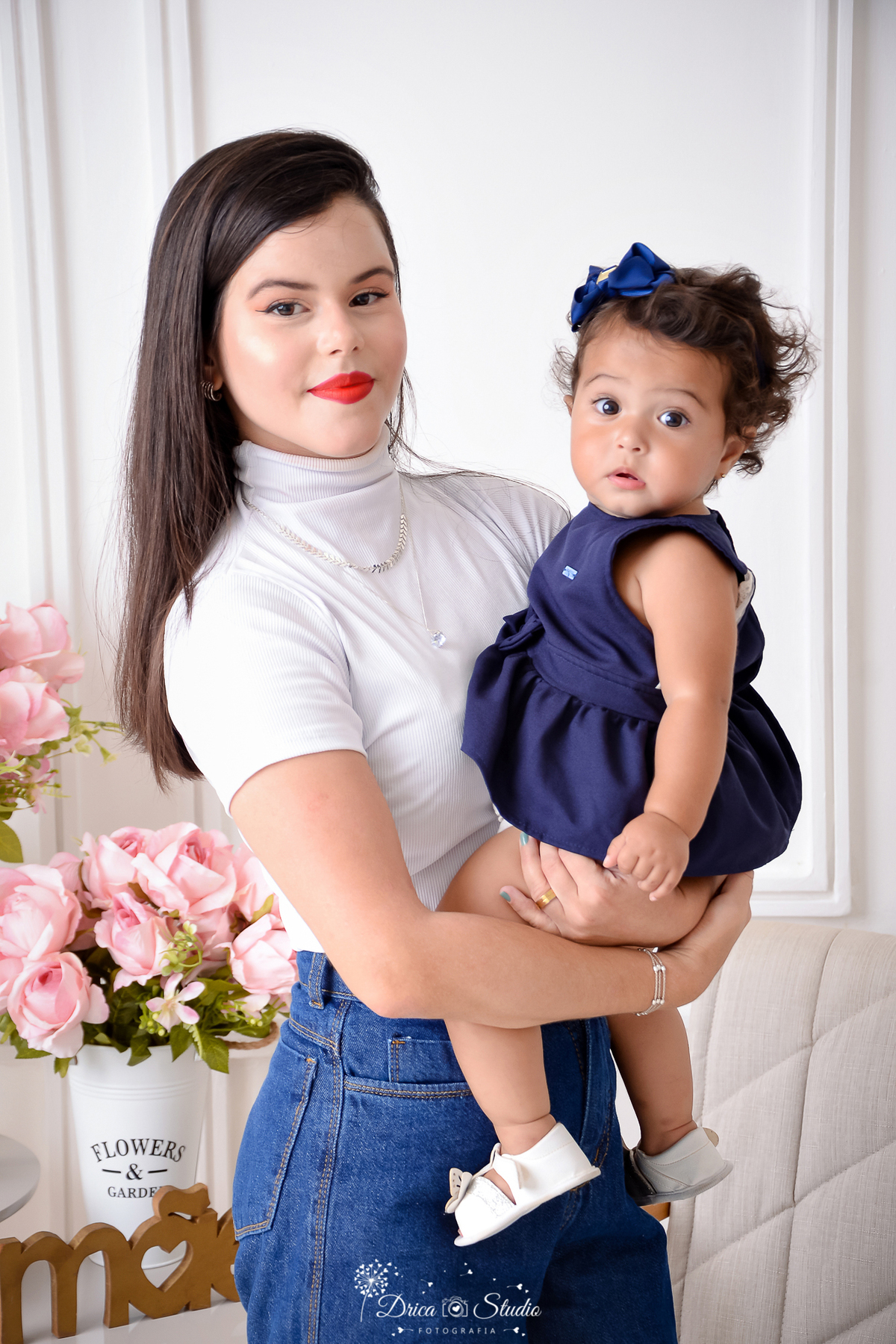 drica studio, ensaio fotografico, xinguara, dia das mães, mãe segurando filha no colo, blusa branca, vestido azul marinho, fundo branco, flores rosa