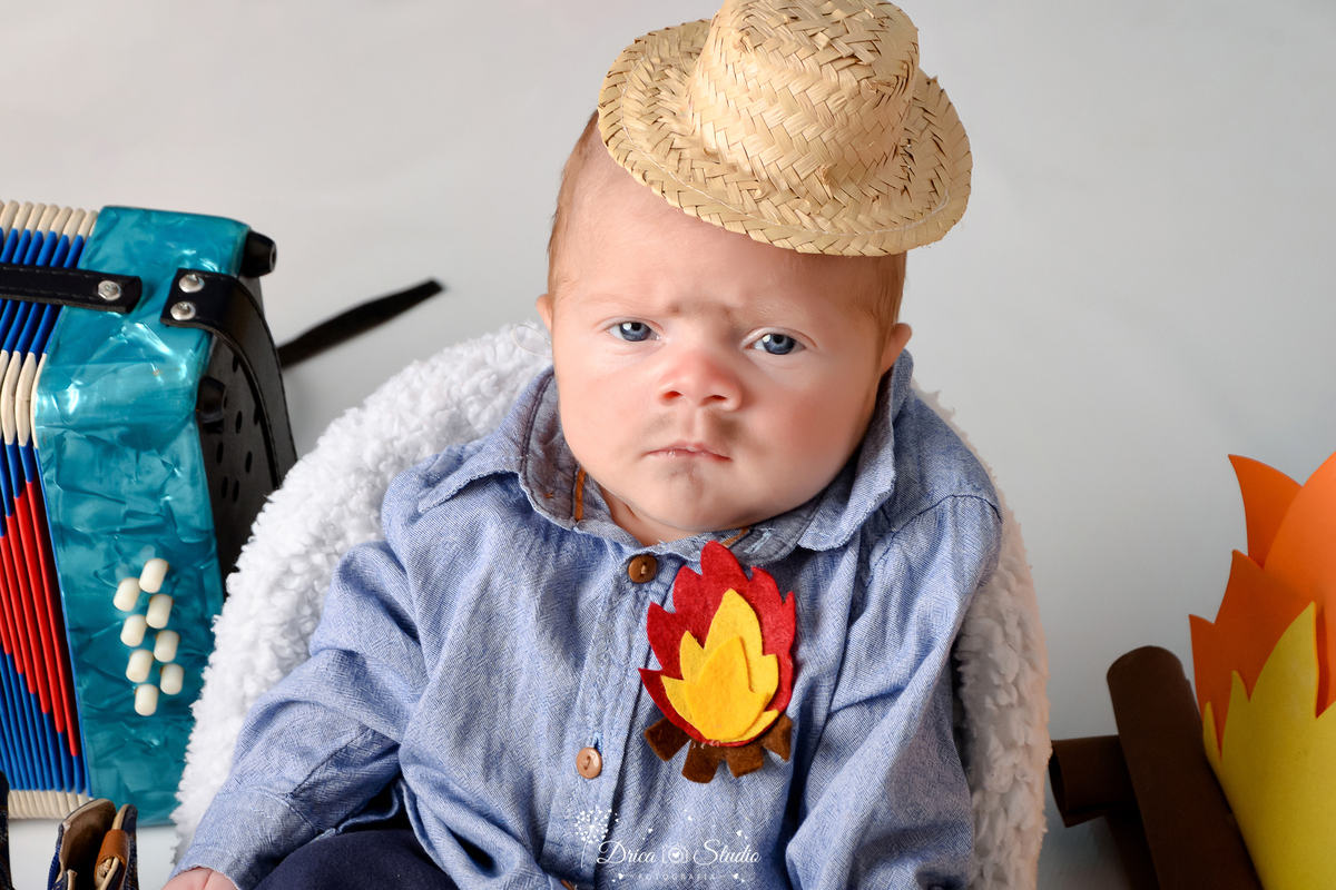Drica studio - ensaio fotográfico infantil- xinguara - festa junina - bebê vestindo com camisa azul - fogueira - sanfona