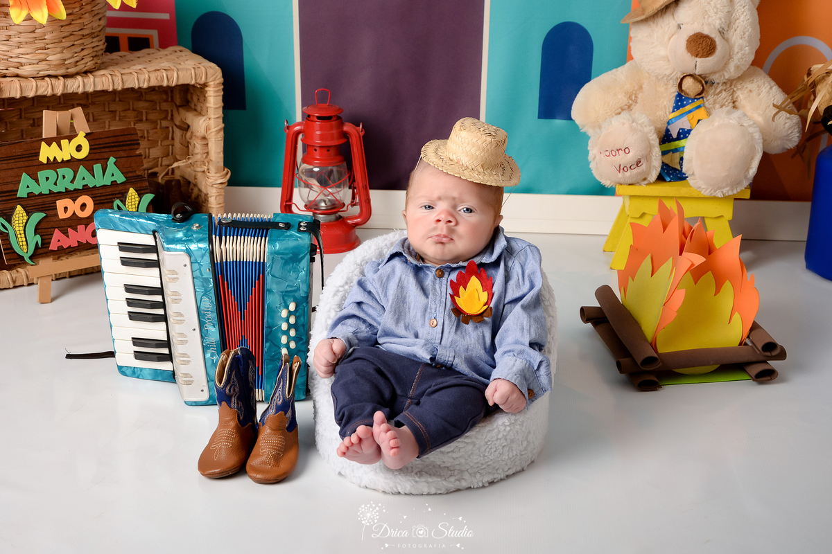 Drica studio - ensaio fotográfico infantil- xinguara - festa junina - bebê com roupa caipira - fogueira - sanfona azul - bota - lampião vermelho - cesto de palha - urso branco com chapéu de palha - fundo tema junino