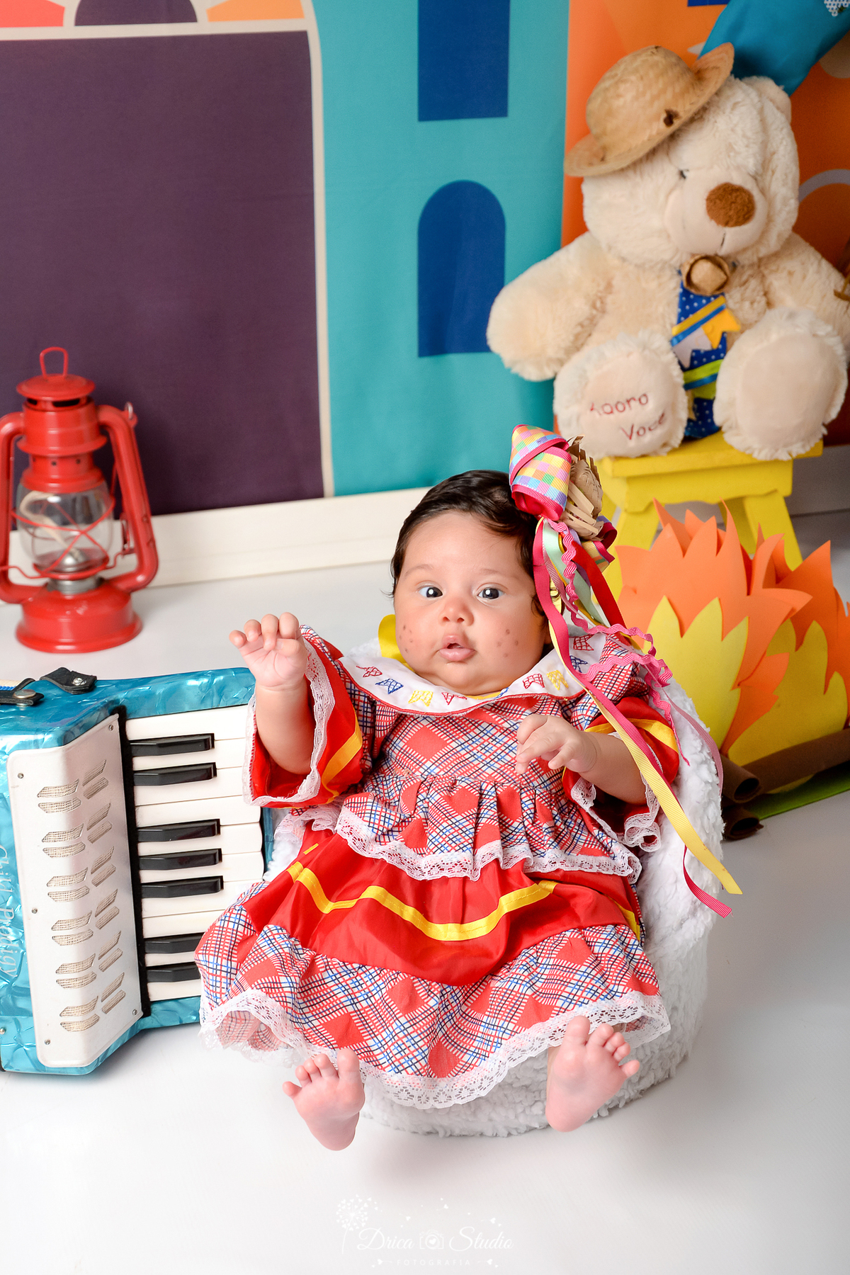 Drica studio - ensaio fotográfico infantil- xinguara - festa junina - lampião vermelho - bebê vestida em vestido junino infantil - fogueira - banquinho amarelo - sanfona azul - lampião vermelho - fundo tema junino