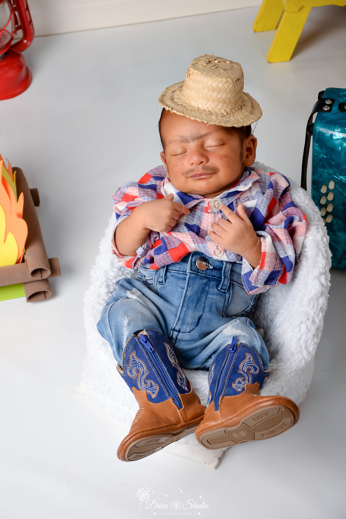 Drica studio - ensaio fotográfico infantil- xinguara - festa junina - bebê vestindo camisa xadrez e calça jeans - poltrona banca - fogueira - sanfona azul - fundo branco