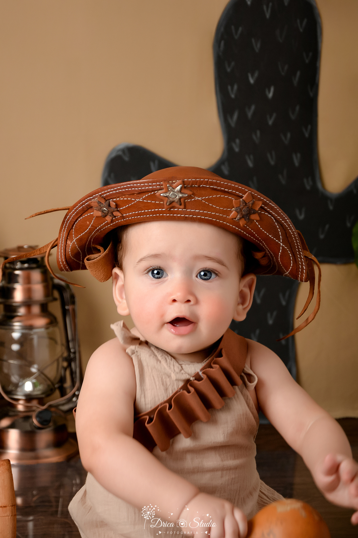 drica studio - ensaio fotografico infantil - tema sertão nordestino - bebê usando chapéu de cordel - lampião antigo - fundo de cordel - roupinha bege