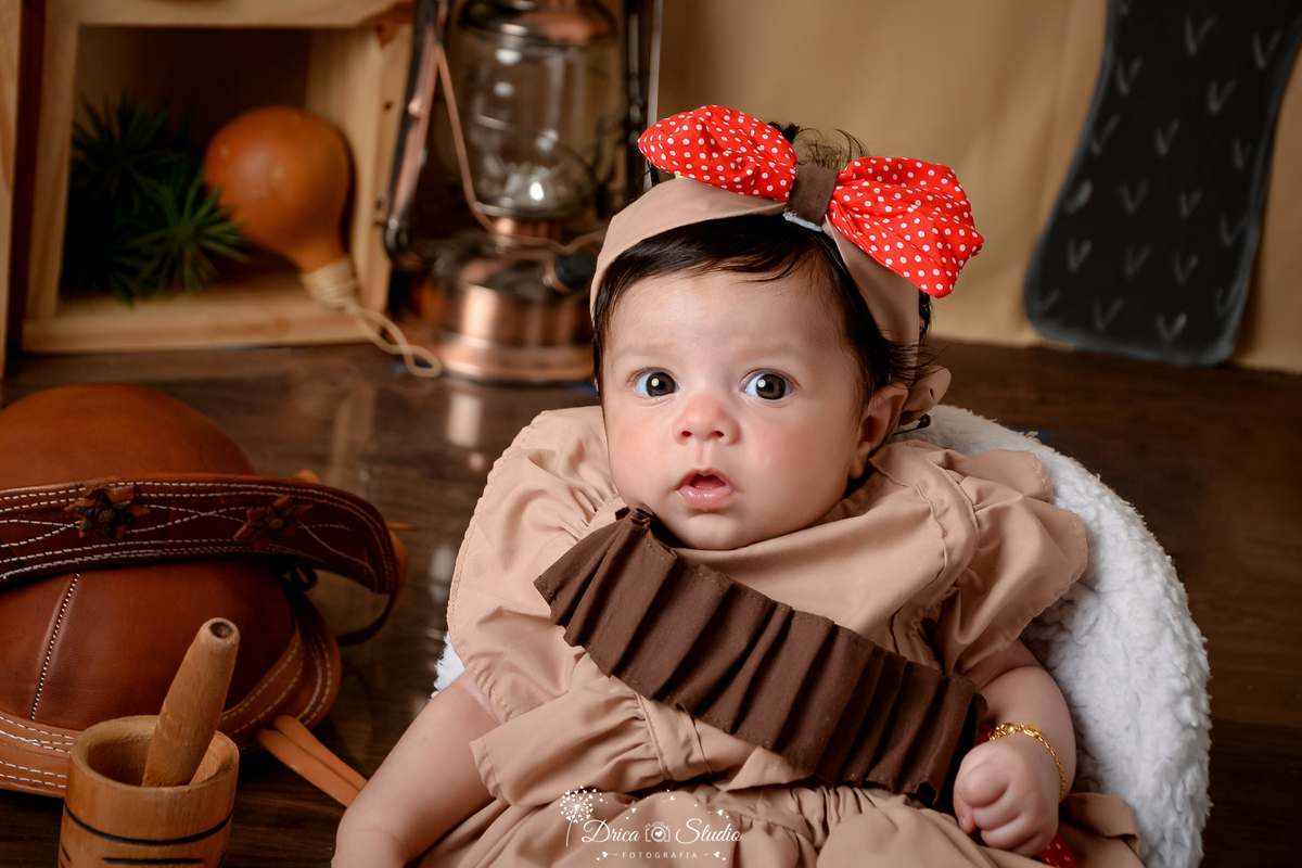drica studio - ensaio fotografico infantil - tema sertão nordestino - bebê vestida com maria bonita - laço vermelho - cabaça - nicho de madeira - lampião antigo - pilão de madeira -  potrona branca - 