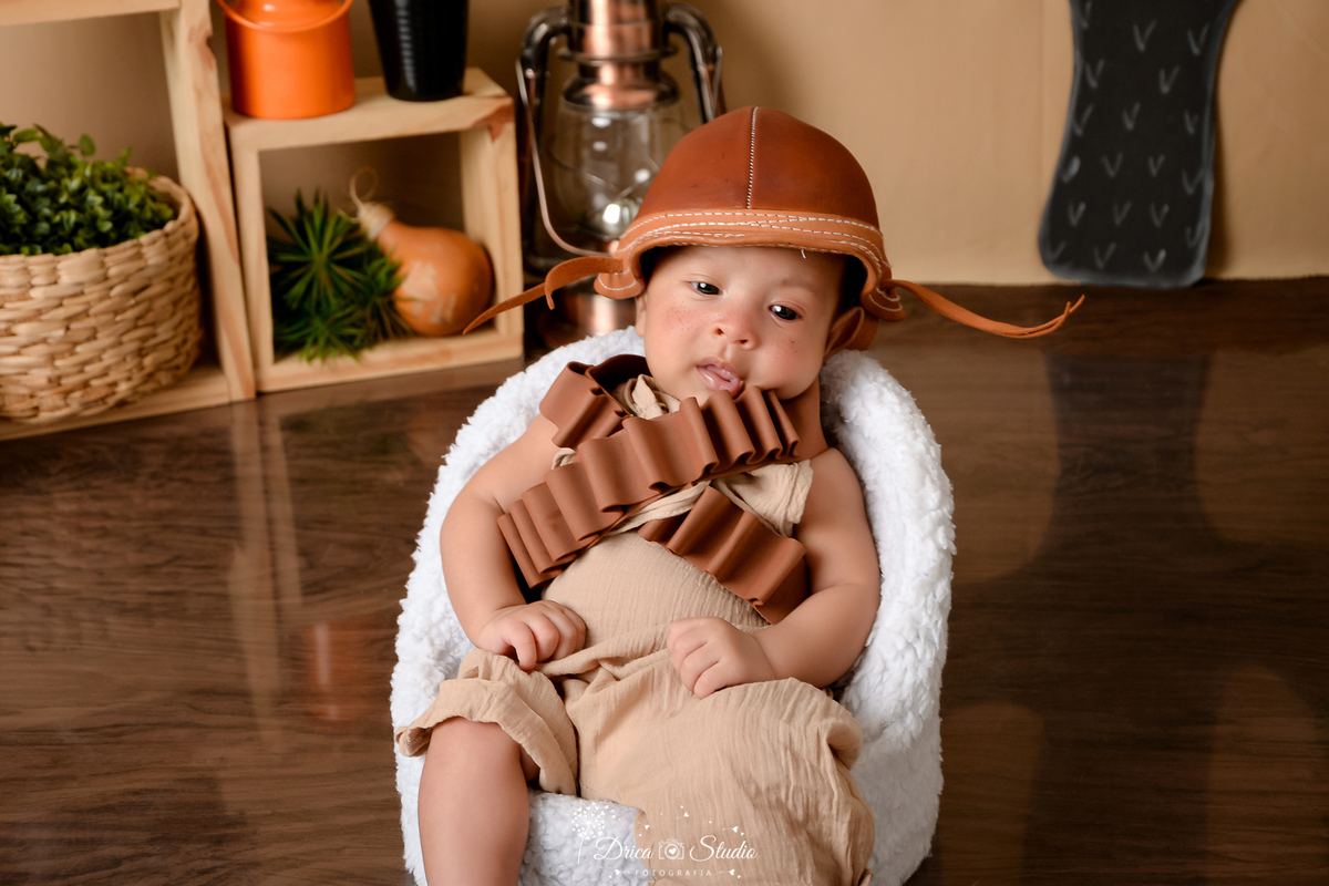 drica studio - ensaio fotografico infantil - tema sertão nordestino - cabaça - chapeu de cangaceiro - fundo de cordel - bebê sentando em poltrona branca