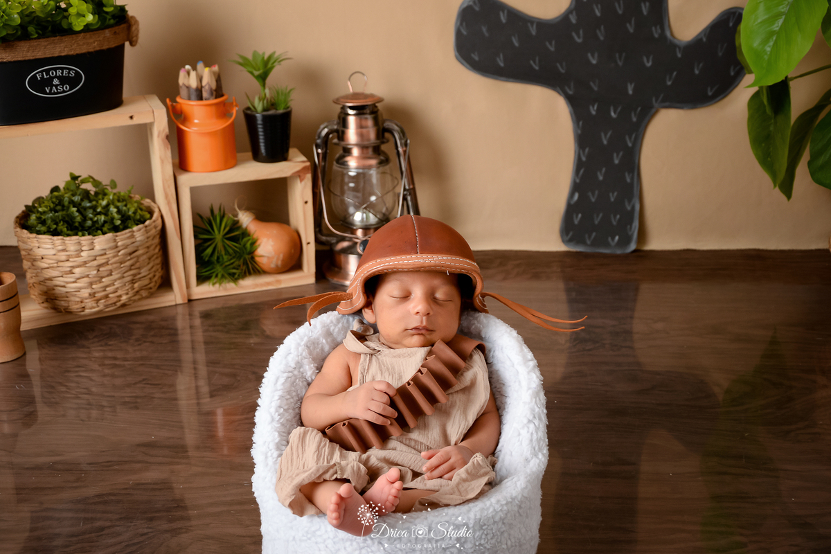 drica studio - ensaio fotografico infantil - tema sertão nordestino - bebê usando chapéu e cinto de bala de cangaceiro - nicho de madeira - latão de leite laranjado - lampião antigo - cesto de palha - fundo de cordel - cabaça