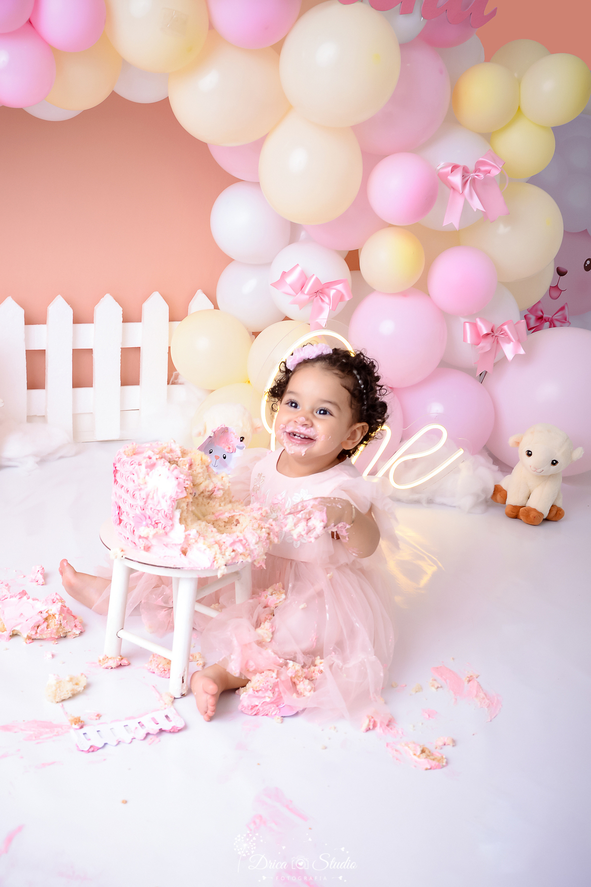 drica studio - ensaio fotográfico infantil - smahs the cake - ovelhinha - xinguara - vestido princesa infantil rosa -  bebê sorridente comendo bolo - cesca branca - ovelha de pelúcia - banquinho branco - vestido de renda e tule - one de led