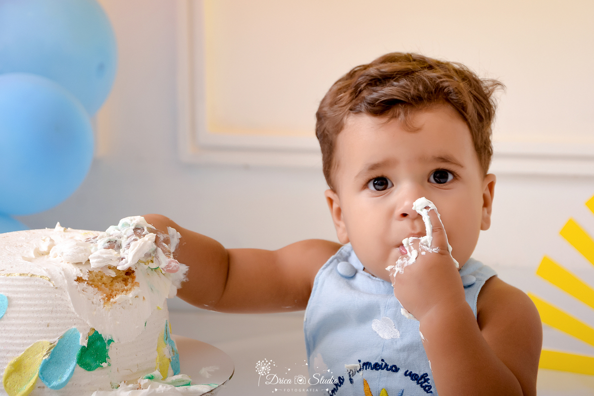 drica studio - ensaio fotográfico infantil - smash the cake - xinguara - uma volta ao soldrica studio - ensaio fotográfico infantil - smash the cake - xinguara - uma volta ao sol - bebê desgustando bolo- macaquinho azul - bolo branca - balão azul 
