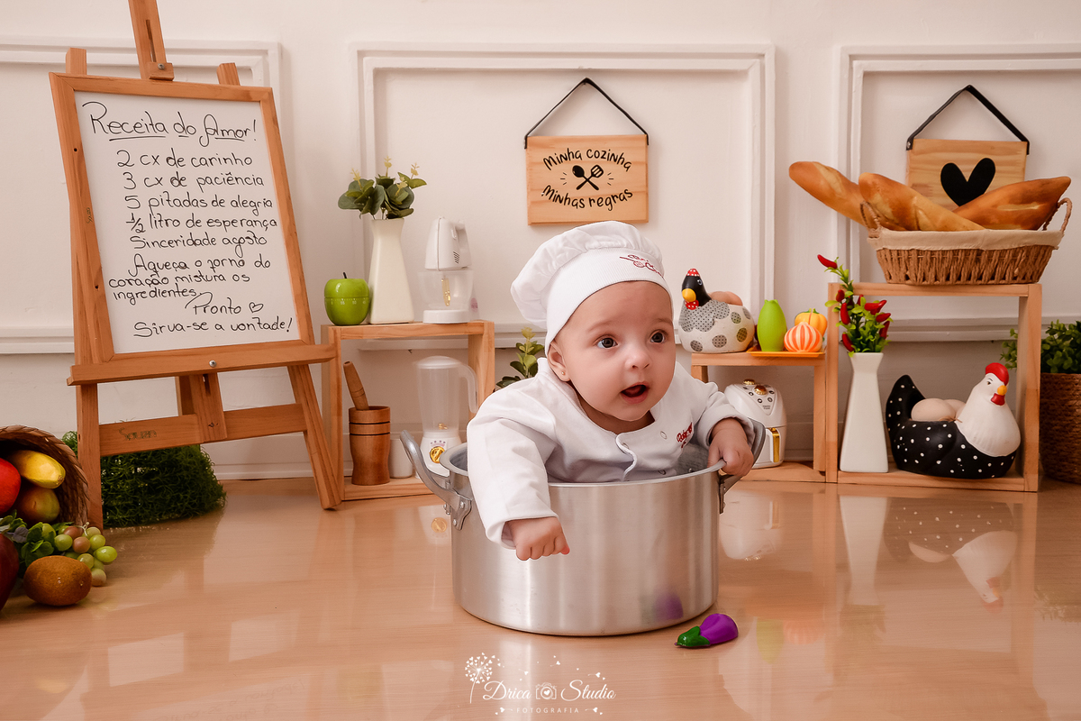 drica studio - ensaio fotográfico infantil - acompanhamento mensal, bebê vestindo roupa e chapéu de chef de cozinha, sentando dentro de panela - cesto com frutas - galinhas decorativas - utensilio de cozinha - placas decorativas-fundo branco com boiserie