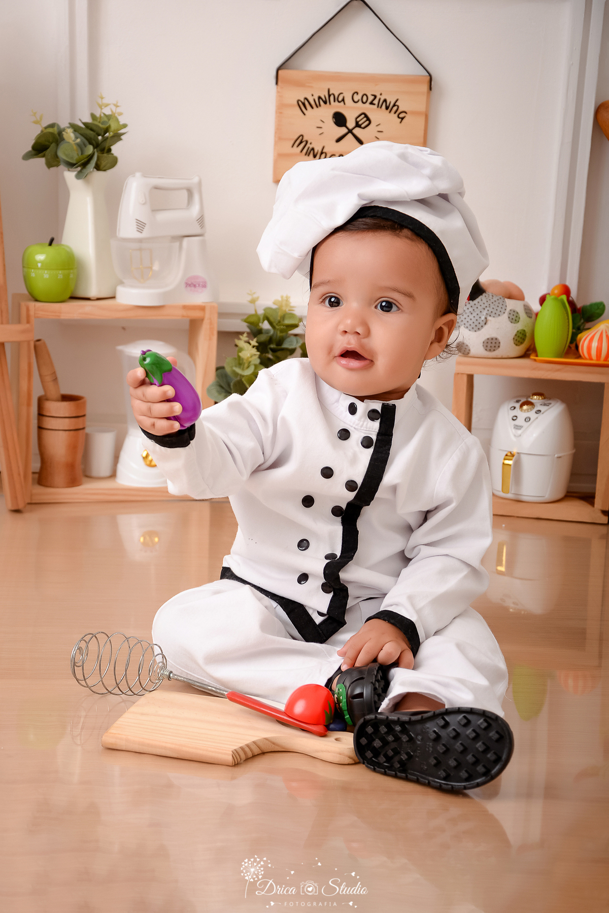 drica studio - ensaio fotográfico infantil - acompanhamento  bebê sentado no chão, vestido de chef de cozinha, segurando uma beterraba - pilão - maça verde 