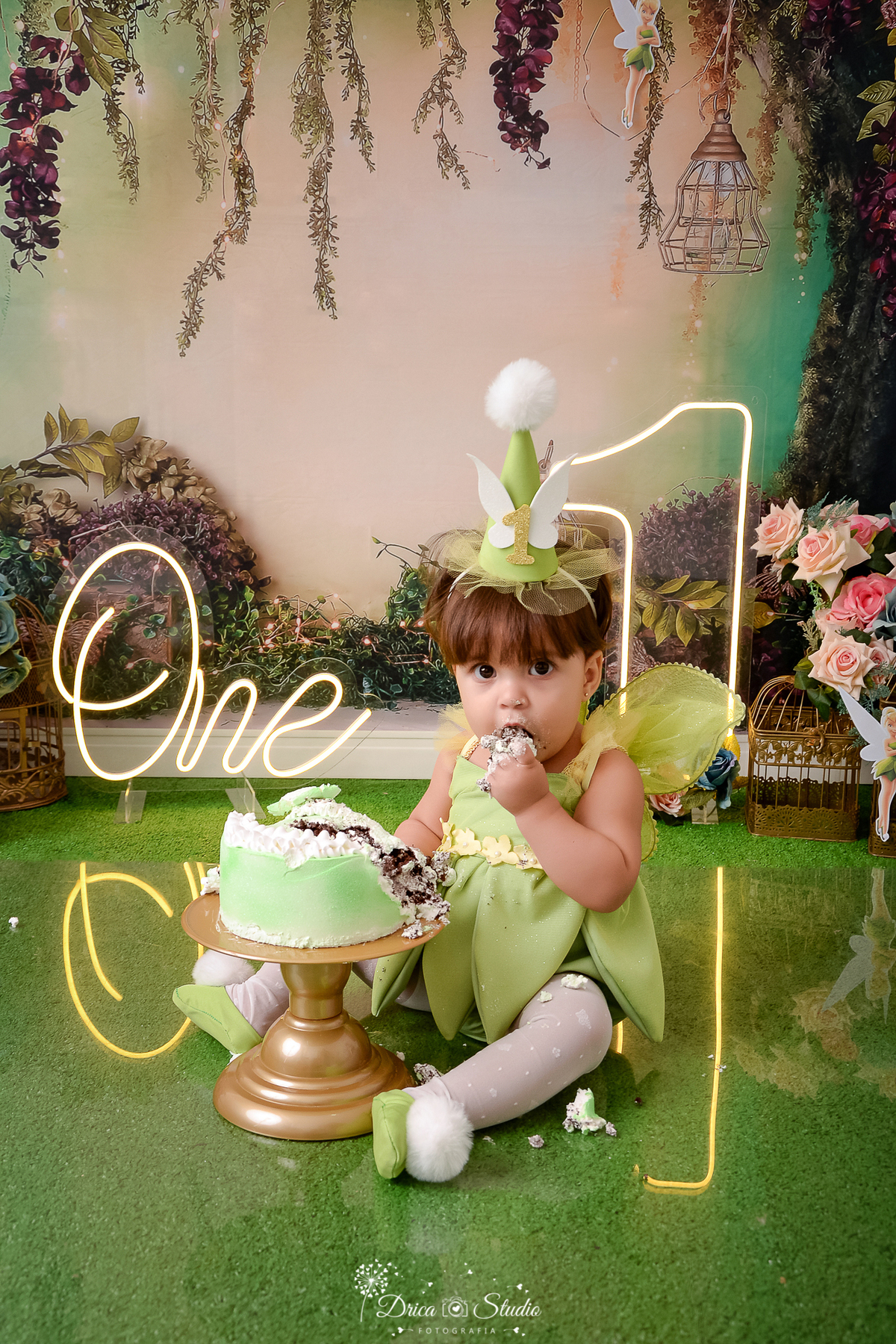 drica studio - ensaio fotografico infantil - smash the cake tinker bell - xinguarar - painel tema floresta - flores - um de led o bebê vestindo fantasia da tinker bell - grama artificial - one de led - bolo verde com branco