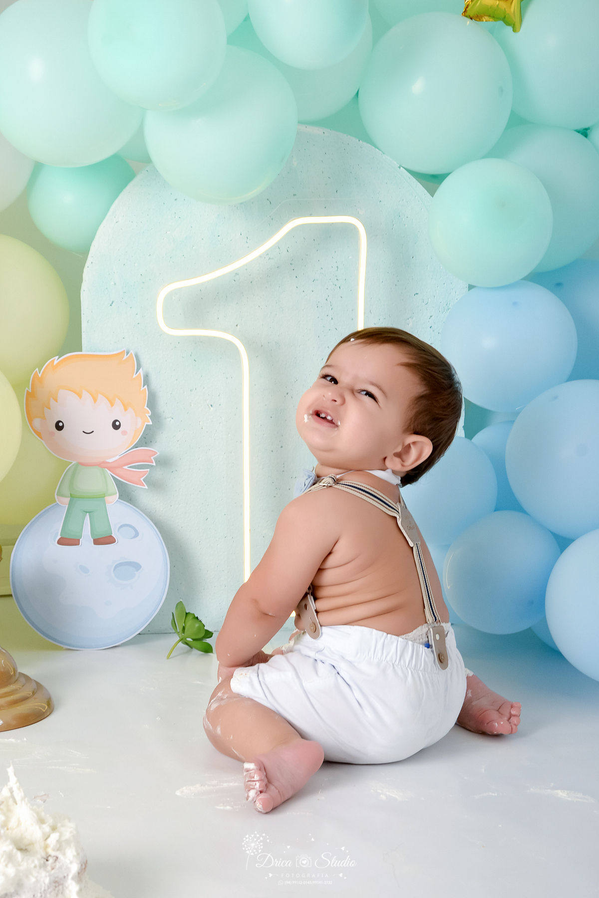 drica studio - ensaio fotográfico infantil - smahs the cake pequen principe - xinguara - bebê sentado de lado fazendo caretinha - pequeno principe em cima da lua - painel azul claro - balões azul e amarelo- um de led - 