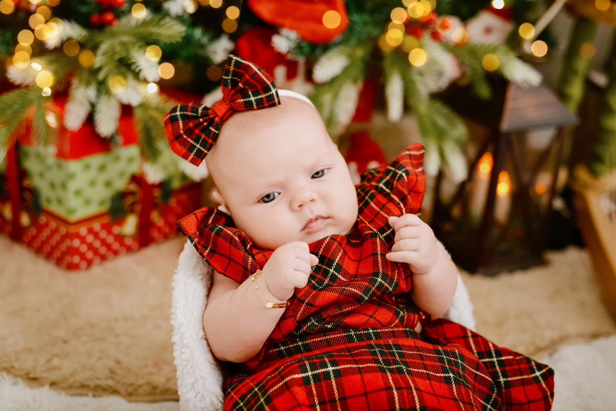 drica studio - ensaio fotografico - xinguara - fotos de natal - bebê vestindo vestindo xadrez vermelho e laça xadrez vermelho na cabeça - árvore de natal - presentes - lampião com velas