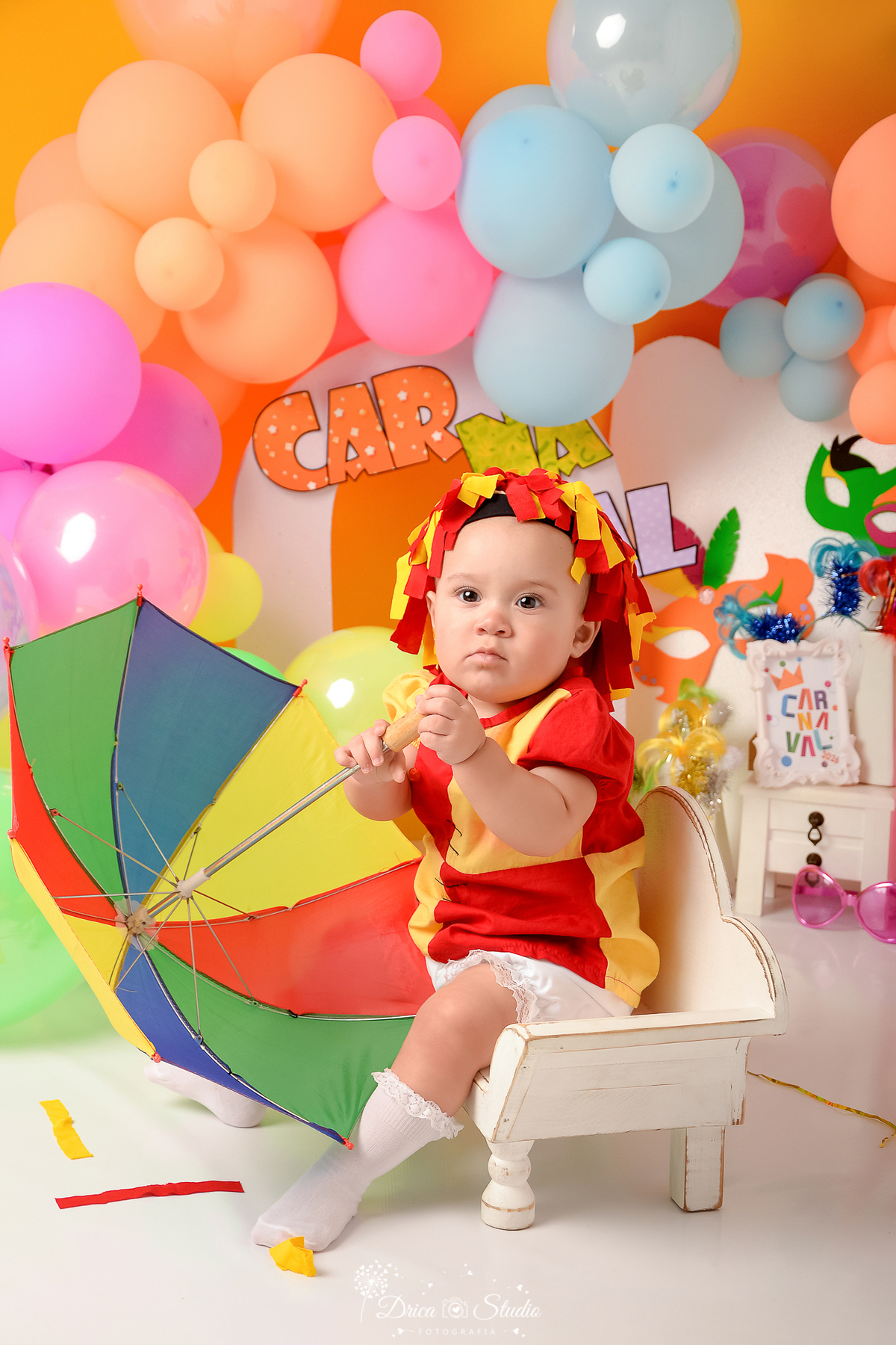 drica studio - ensaio fotográfico infantil - carnaval- xinguara - pará - bebê vestida de emilia, segurando sombrinha de frevo- balões coloridos - máscaras de carnaval - painel branco e lilas - penteadeira branca - fundo amarelo