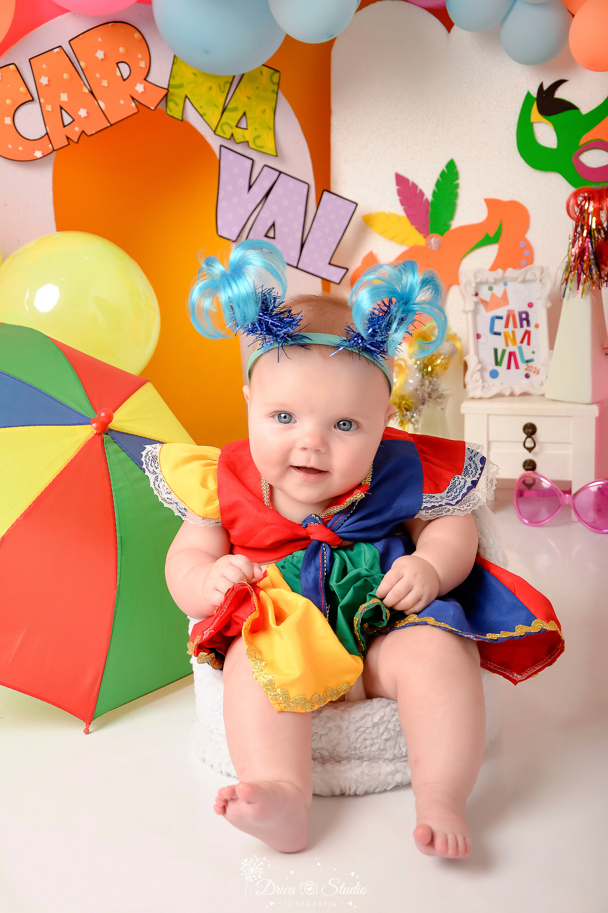drica studio - ensaio fotográfico infantil - carnaval- xinguara - pará - bebê usando roupa de frevo e tiara de coqueiro azul - sombrinha de frevo - fundo amarelo - penteadeira branca - balões coloridos