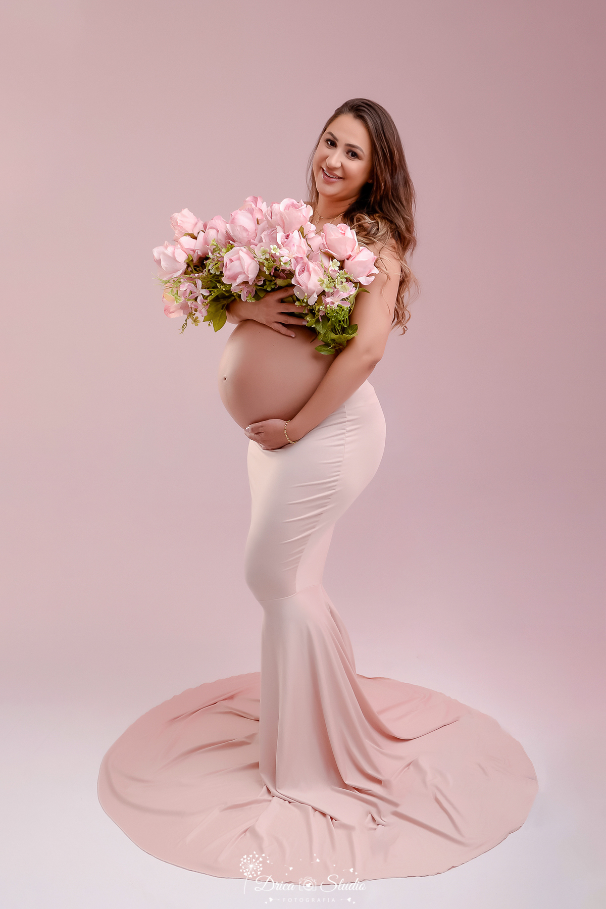 drica studio - ensaio fotografico gestação - xinguara - pará - gestante em estúdio com vestido nude e buquê de flores rosas - barriga de gestação a amostra