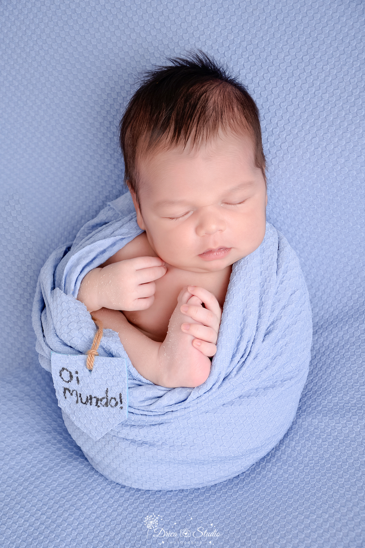 rica studio-ensaio fotografico recém-nascido- newborn-xinguara - pará - bebê rece-nascido enrolado em manta azul, com o pé de fora - fundo azul