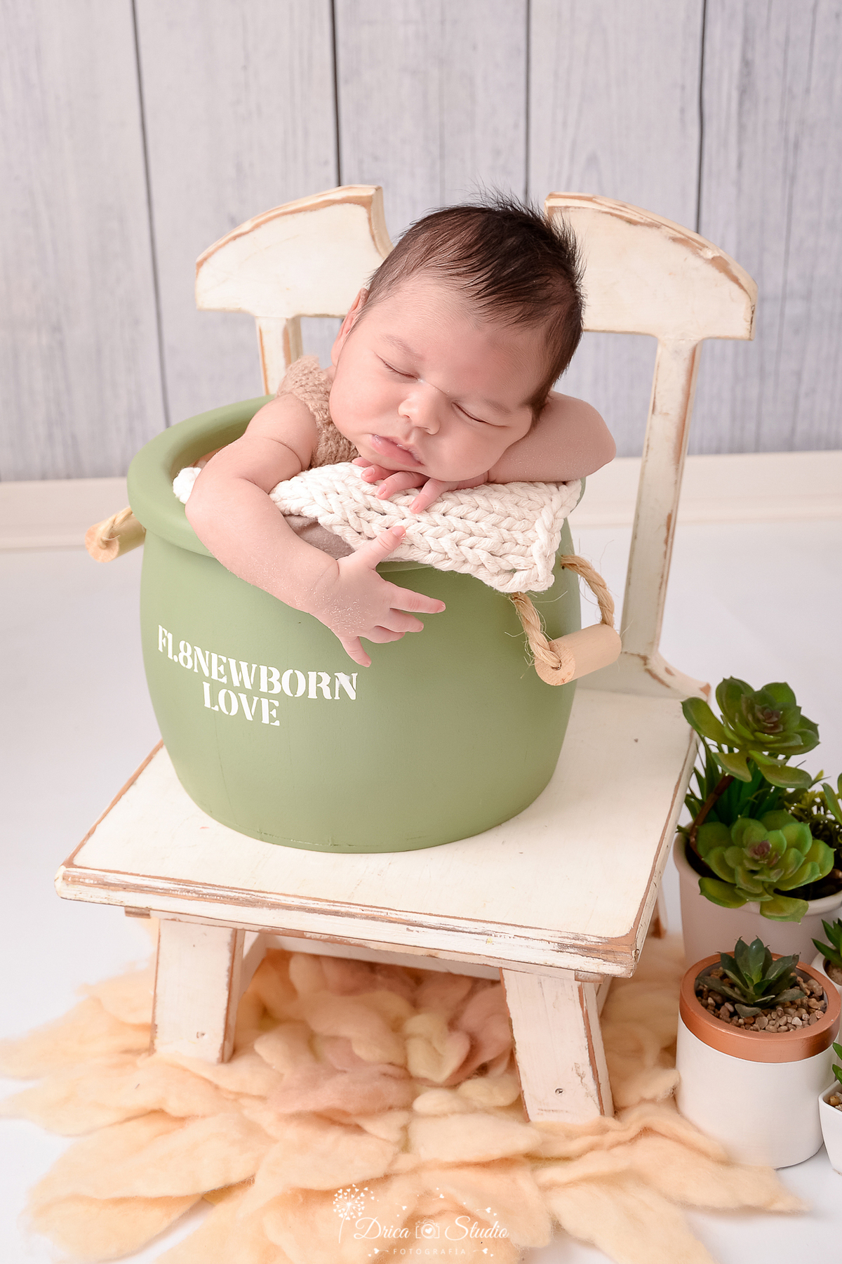 rica studio-ensaio fotografico recém-nascido- newborn-xinguara - pará - bebê recém-nascido dormindo dentro de baldinho verde, acochoado com mantas de tricô - sobre uma cadeira branca - vasinho com suculenta - fundo amadeirado