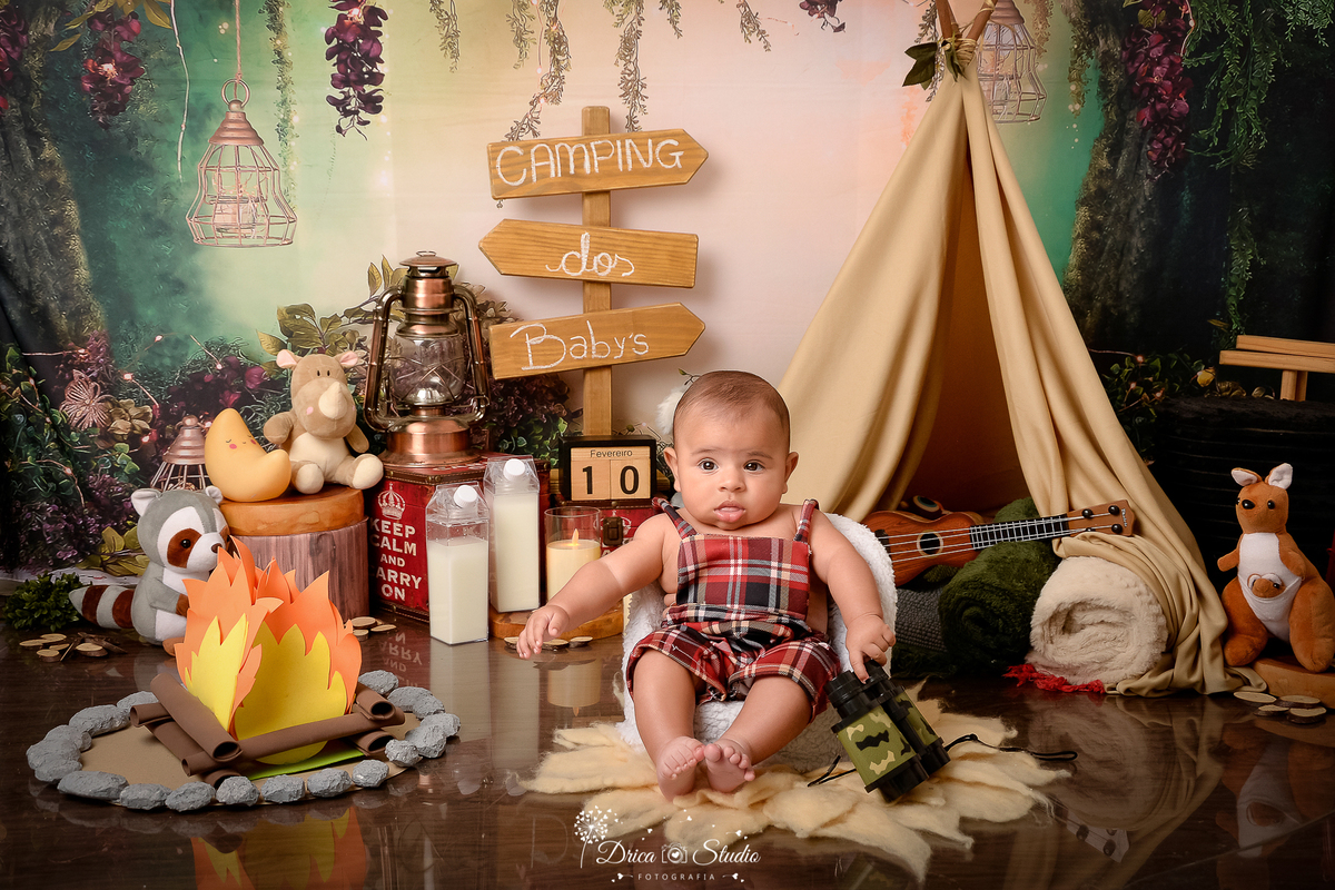 drica studio-ensaio fotografico infantil - acampamento infantil - xinguara - pará - bebê sentado em poltrona branca , usando macaquinho xadrez - binoculo - fogueira de eva - bichinhos de pelúcia - lampião - caixa de leite - fundo tema floresta