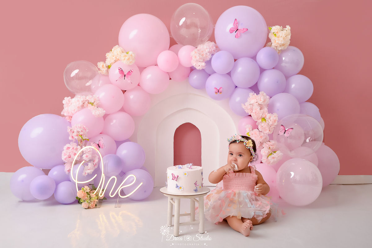 drica studio - ensaio fotográfico infantil - smash the cake - tema jardim de borboletas - xinguara - pará-balões lilas e rosa - borboletas e flores rosa - painel branco - one de led - bolo branco - banquinho branco - fundo rose