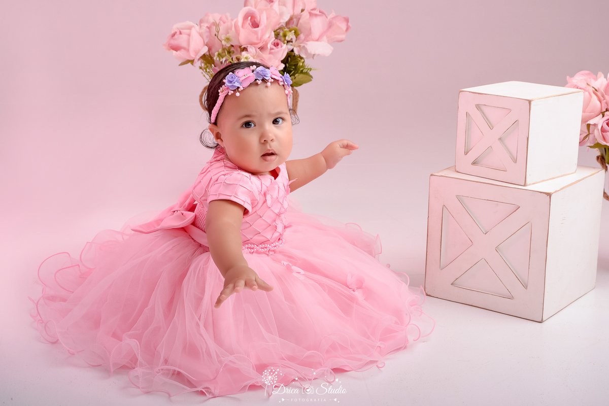 drica studio - ensaio fotográfico infantil - smash the cake - tema jardim de borboletas - xinguara - pará - vertido de princesa rosa com renda e tule - caixotes branco - vaso com flores rosa - fundo neutro