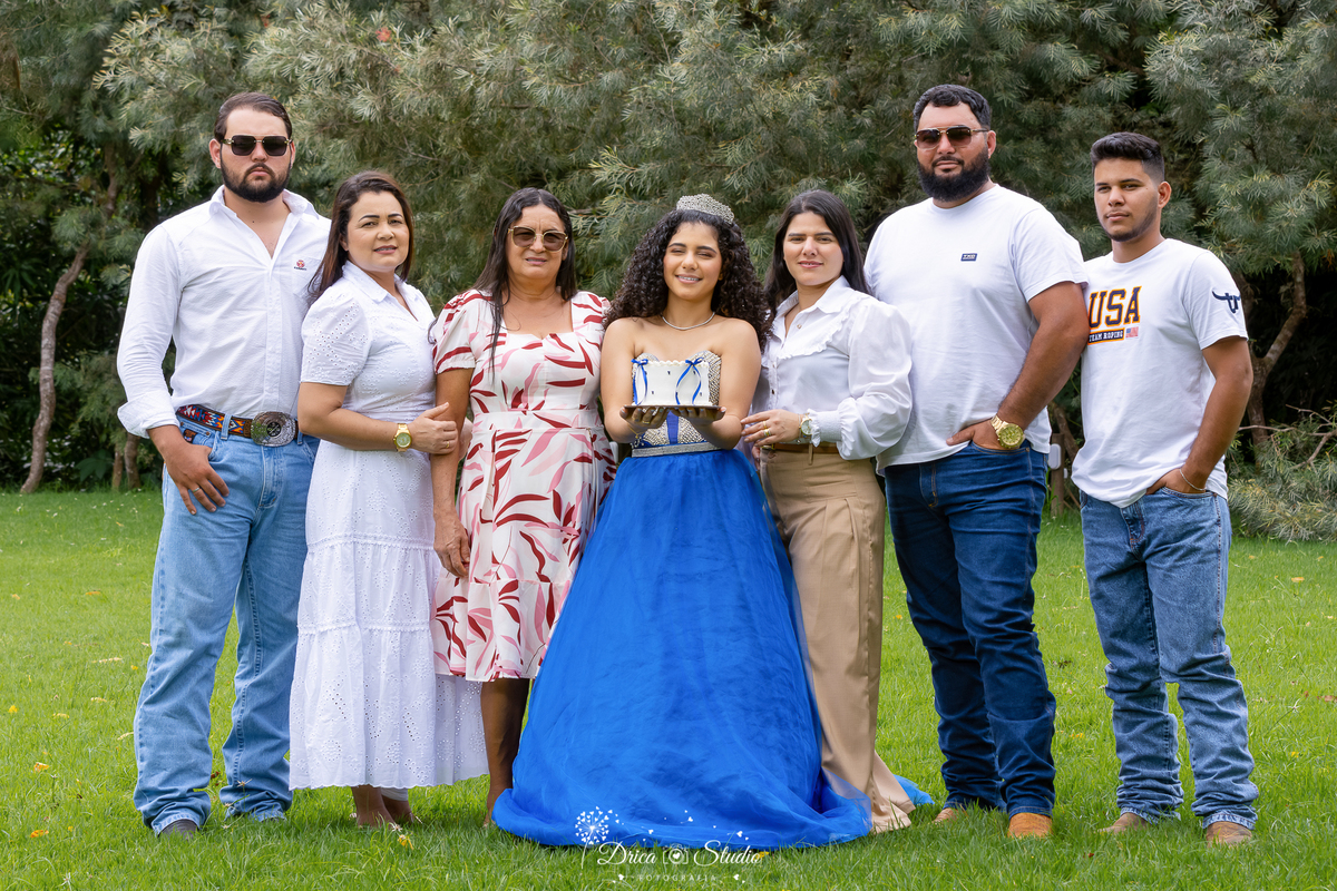 drica studio - ensaio fotografico - 15 anos - debutante - xinguara - pará - ao ar livre - debutante posa para foto com a família - em campos verde e bosque ao fundo