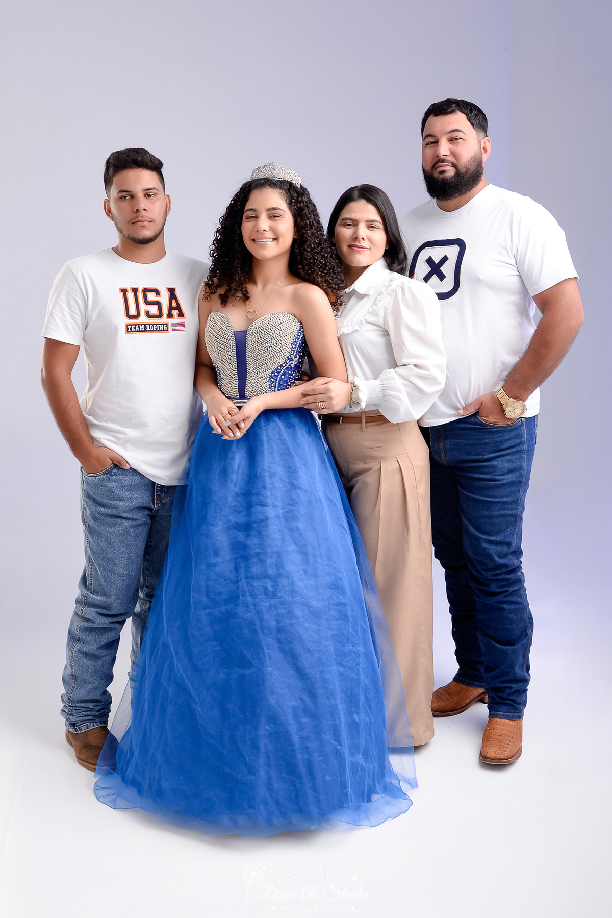 drica studio - ensaio fotografico - 15 anos - debutante - xinguara - pará - debutante paso para foto com os pais e o irmão - ela usa vestido azul  com pedraria no corpo do vestido 