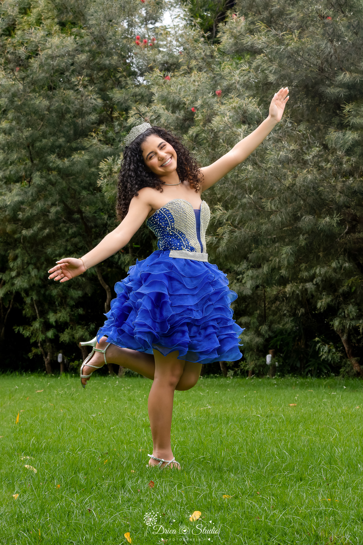 drica studio - ensaio fotografico - 15 anos - debutante - xinguara - pará - jovem pousa para foto ao ar livre, ela usa vestido de festa azul, corpo com pedraria e saio com babados - sandália prata - ao fundo bosque