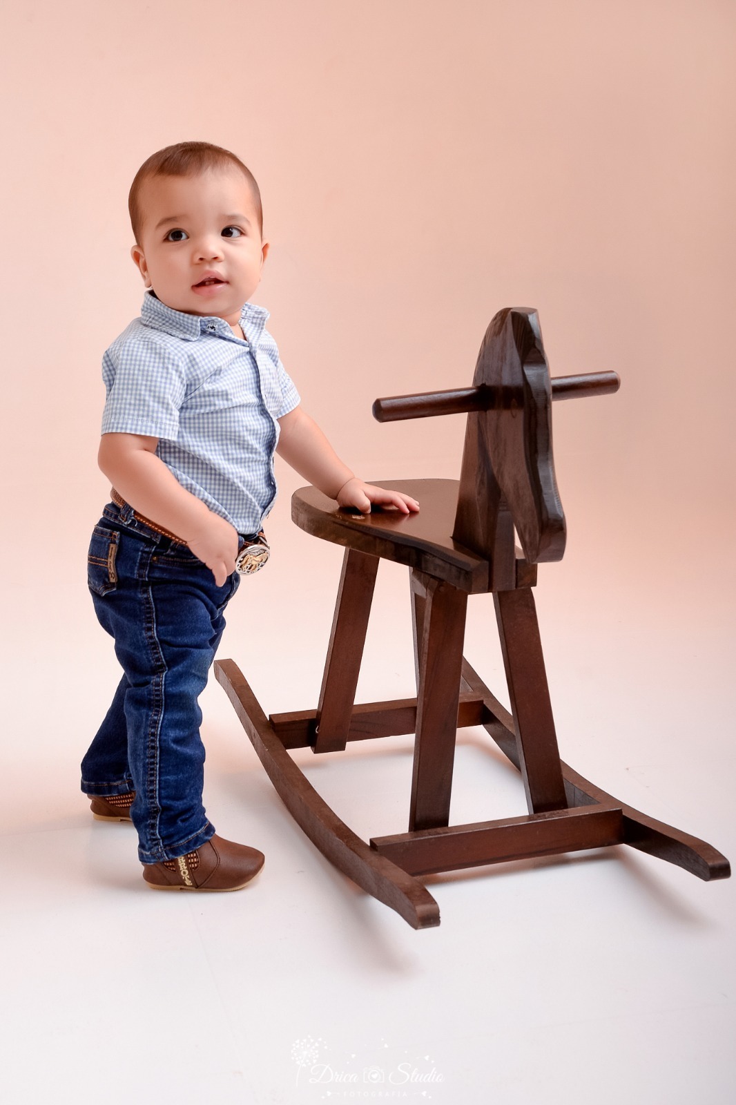 drica studio - ensaio fotografico - fotos em estúdio - xinguara/pá - smash the cake - bebê em pé - segurando num cavalinho de madeira -  usando camisa xadrez - calça - cinto - bota - 