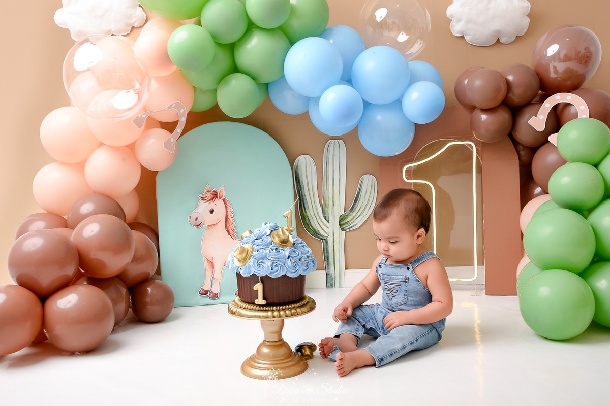 drica studio - ensaio fotografico - fotos em estúdio - xinguara/pá - smash the cake - cenário country -  com balões - bolo em formato de cupcake - bebê sentado - usando macacão jeans - primeiro contato com o bolo 