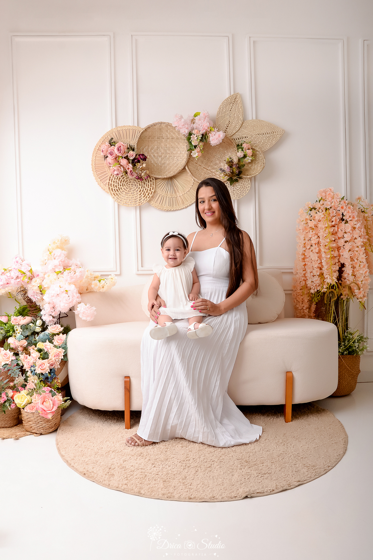drica studio - especial de dia das mães - mães e filhos - xinguara - pará - mãe e filha usando vestido branco - cenário branco com flores - acompanhamento mensal - bebê sorrindo 