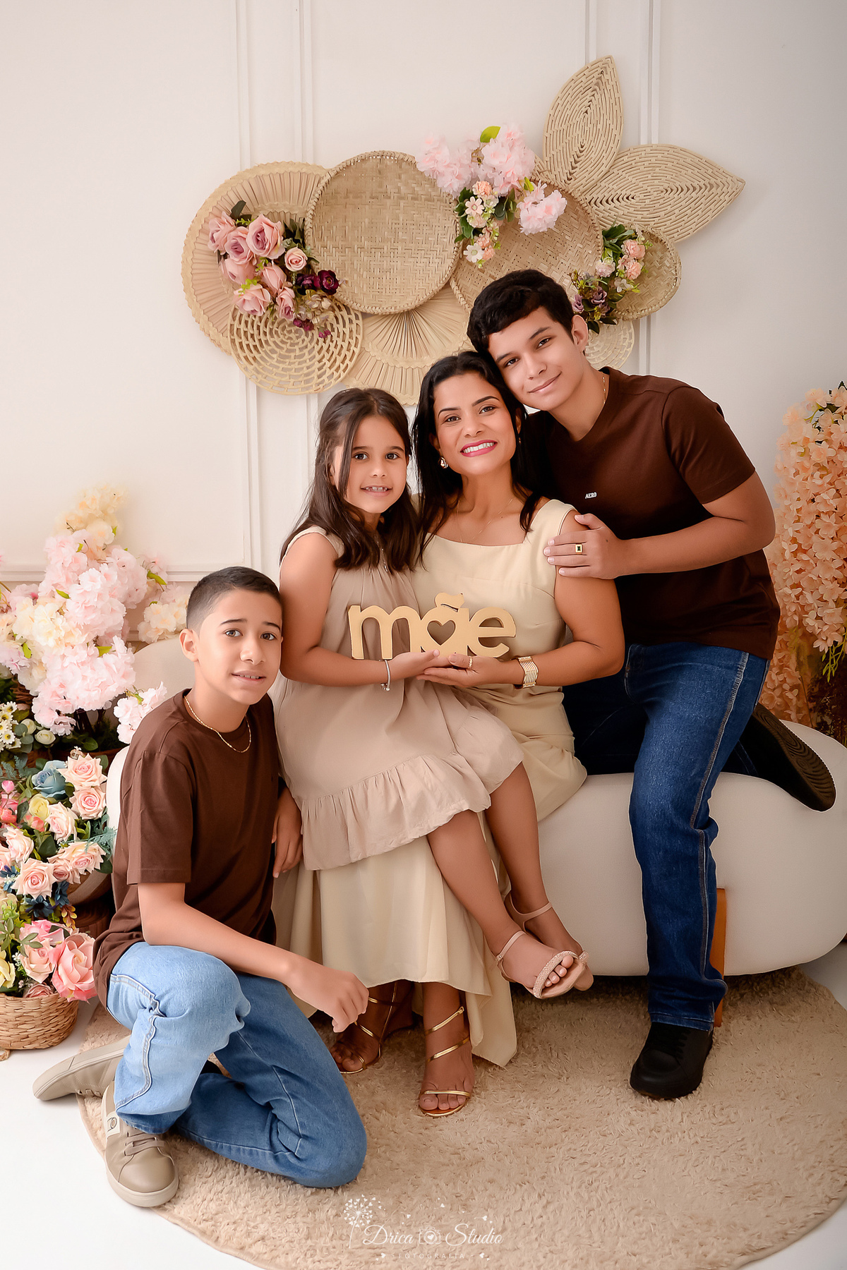 mãe e três filhos - mãe de 3 - cenário dia das mães - cenário com flores - fundo branco -  sófa branco - drica studio 