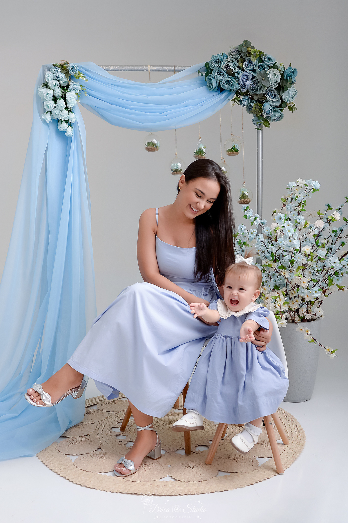 mãe e filha - usando vestidos azuis - cenário de dia das mães - fundo azul - flores azuis  - drica studio - xinguara - pará 
