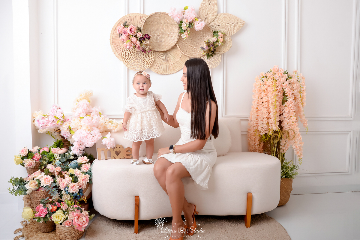 drica studio - especial de dia das mães - mães e filhos - xinguara - pará - mãe e filha usando vestido branco - cenário branco com flores - acompanhamento mensal - bebê sorrindo - mãe e filha usando vestido branco - cenário branco com flores 