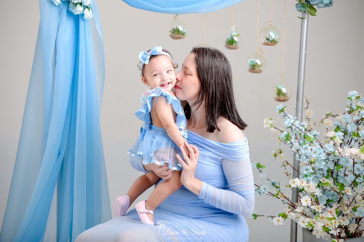 drica studio - especial de dia das mães - mães e filhos - xinguara - pará -  mãe e filha usando roupas azuis - fundo com flores azuis - acompanhamento mensal - bebe sorrindo - primeiro dia das mães 