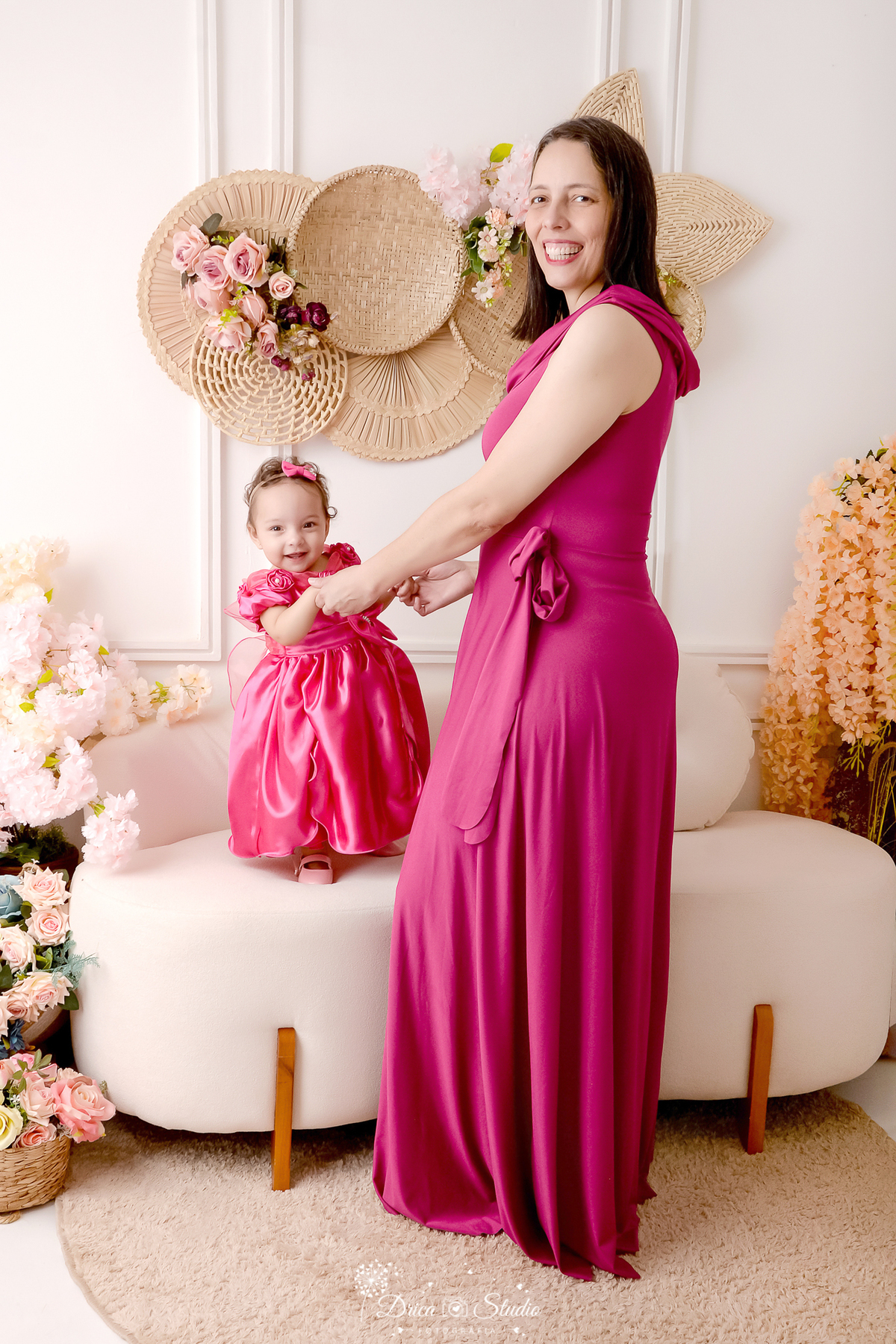 drica studio - especial de dia das mães - mães e filhos - xinguara - pará -  mãe e filha usando vestido rosa - cenário branco com flores - bebê sorrindo - acompanhamento mensal 