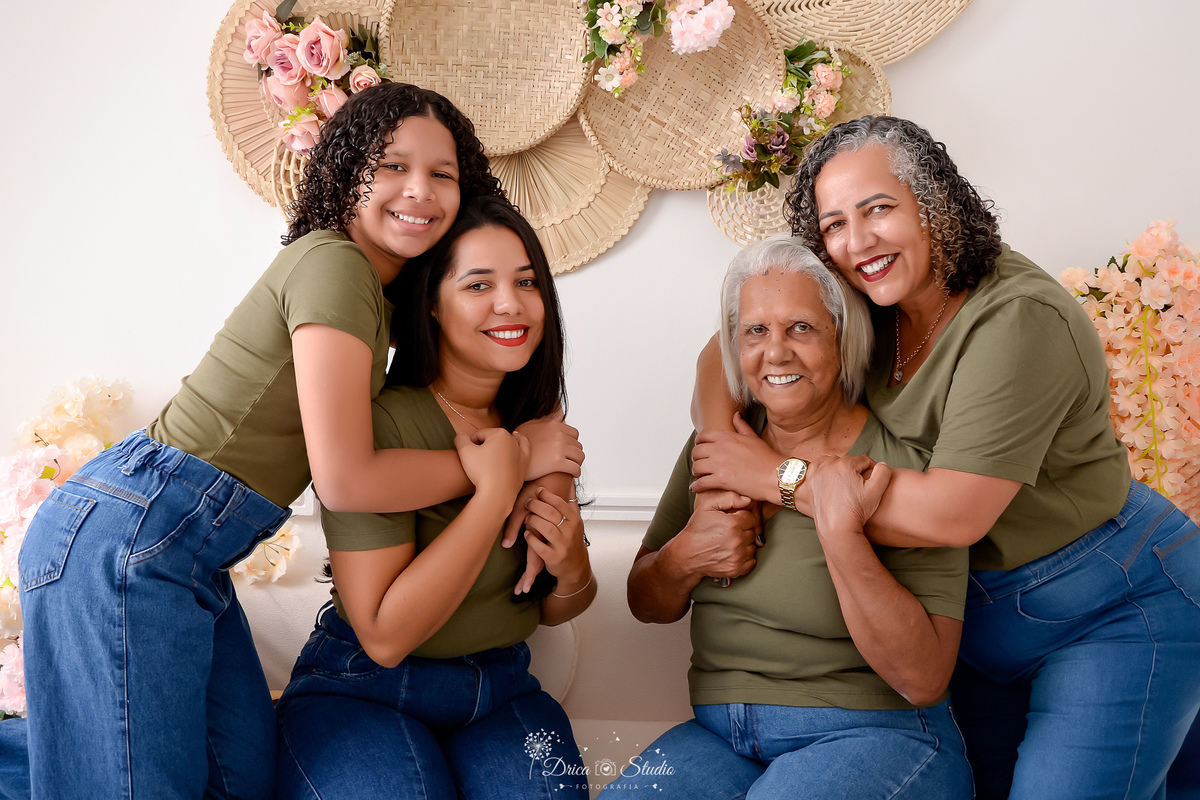 drica studio - ensaio familia - 4 gerações - bizavó - avó - mãe - filha - mãe e filha e abraçadas - cenário branco com flores - familia reunida - sentadas no sofá 