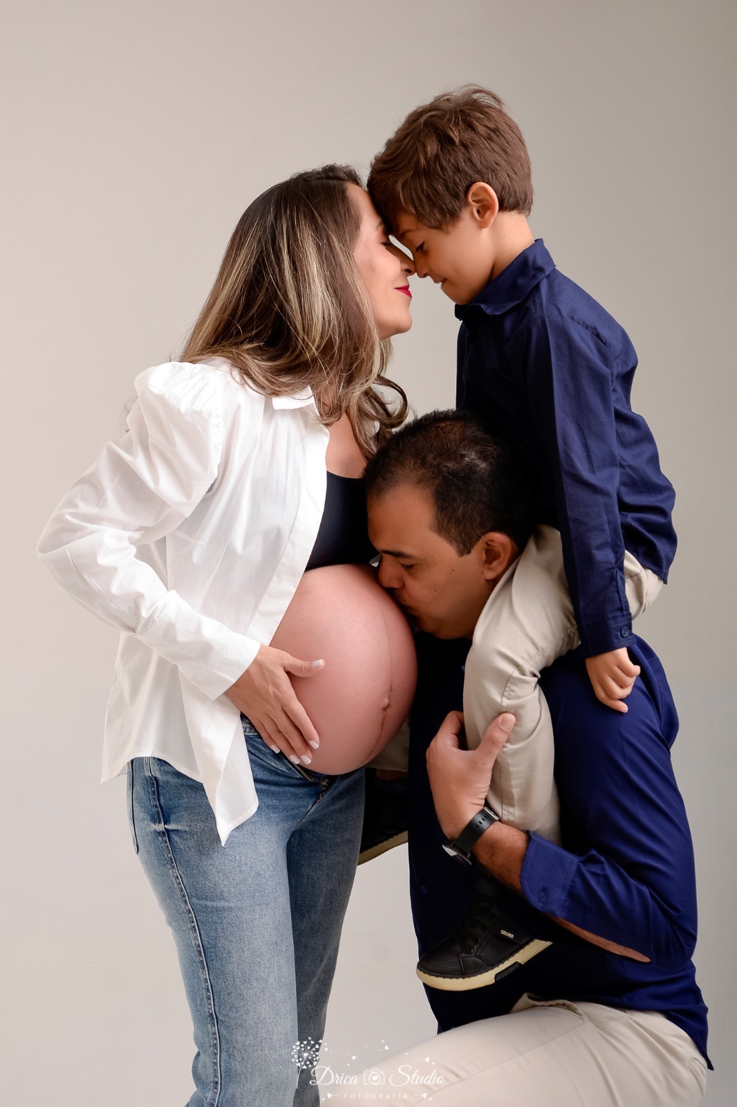 dricastudio - ensaio gestante - mamãe de segunda viagem - mãe de menino - xinguara - pará - familia - pai beijando a barriga da mamãe - foto em estudio -com fundo branco - 