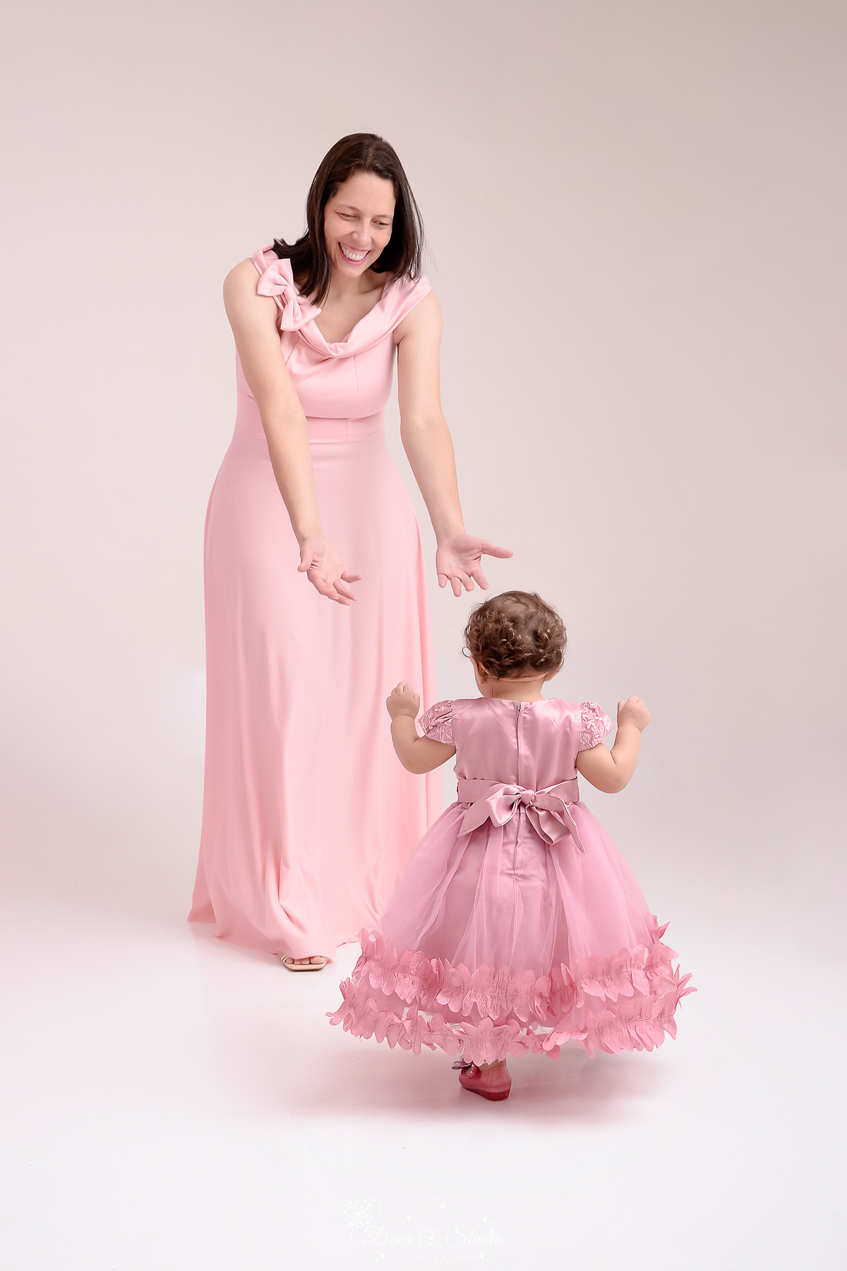 drica studio - smash the cake - jardim encantado - fotos em estudio - mamãe chamando a filha - bebê dando os primeiros passinhos - mãe e folha usando vestido rosa - foto em estudio 