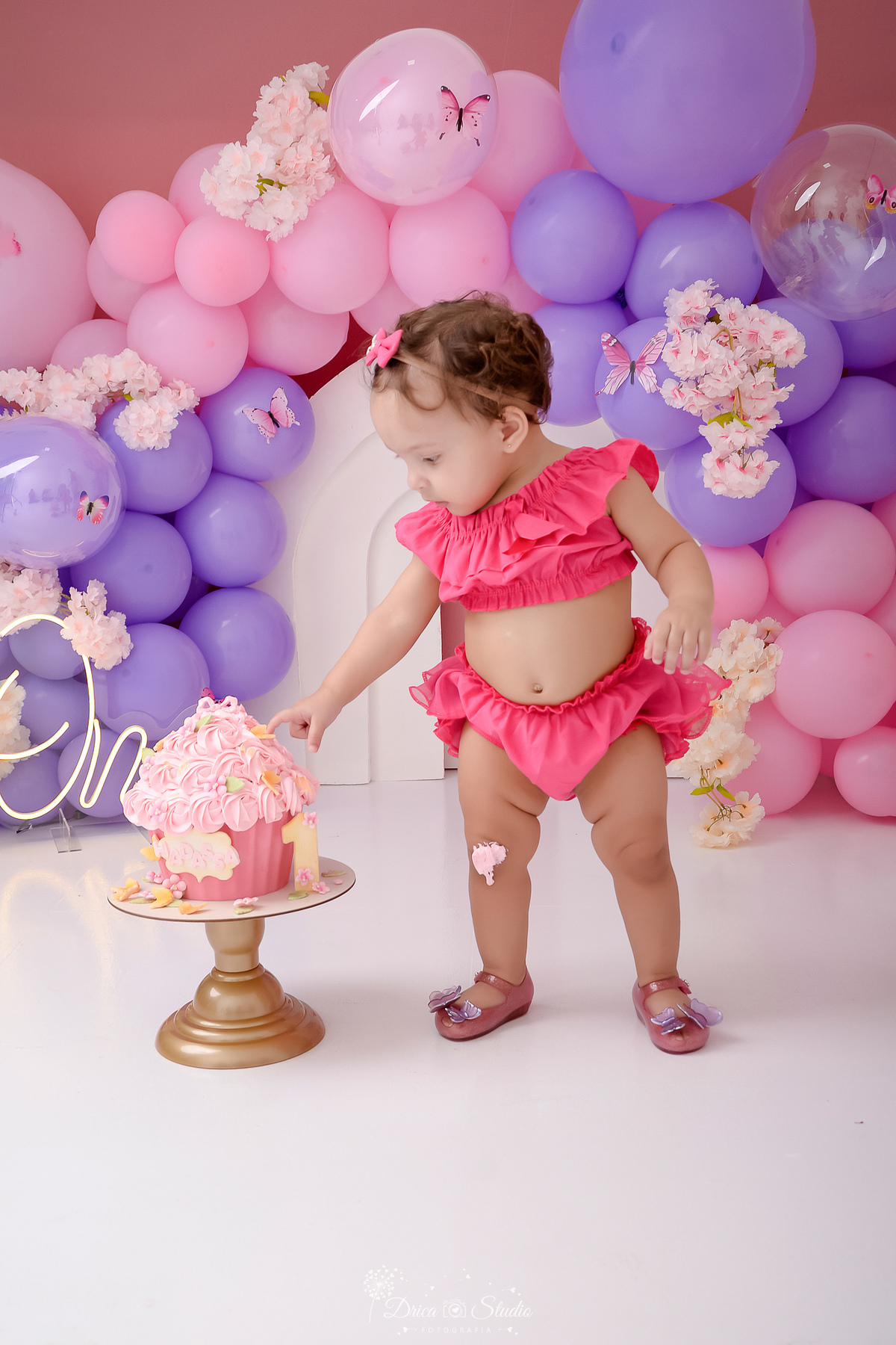 drica studio - smash the cake - jardim encantado - fotos em estudio - bebê tocando no bolo - cenário com balões rosas e azuis - flores e borboletas - bolo cupcake 