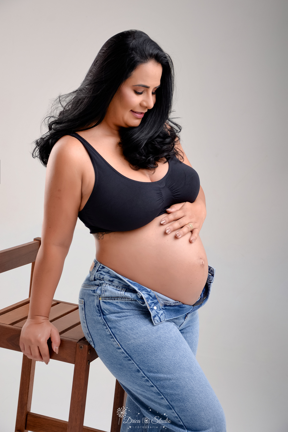 EnsaioGestante - MeninaACaminho - ÀEsperaDaPrincesa - PrimeiraFilha - FotografiaGestante Família - Gestação - MemóriasParaSempre - drica studio - fotos em studio - gestante usando calça jeans e tope preto - 