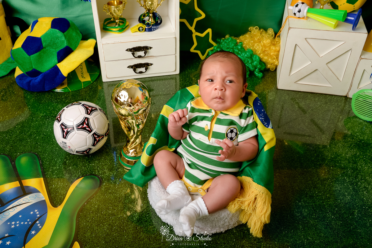 Drica Studio - Copa2026 -Lembrança especial primeira copa - cenário de copa - verde, amarelo e azul - bebê usando bory do brasil - sentado em uma cadeirinha branca - 