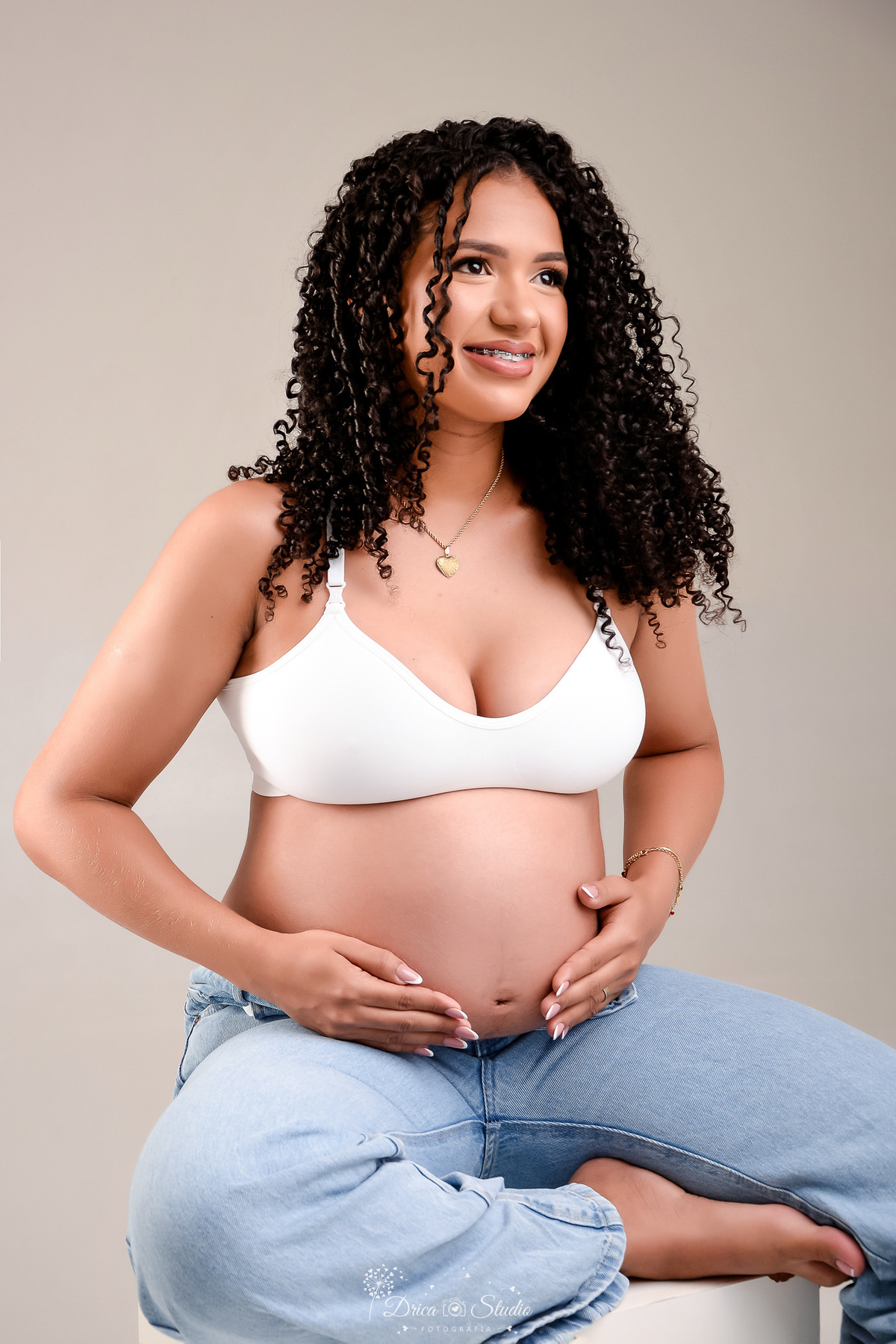 drica studio - ensaio gestante - primeiro filho - fotos em estudio - xinguara - pará - mãe usando top branco - com as mãos na barriga 