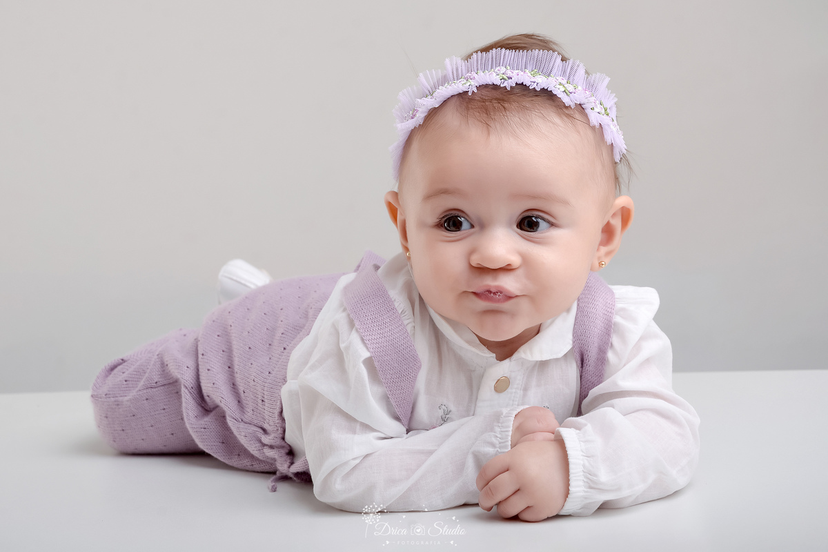 drica studio - acompanhamento mesal - 4 meses - xinguara - pará - bebe deitado em baquinho - usando roupinha brancaa com lilás 