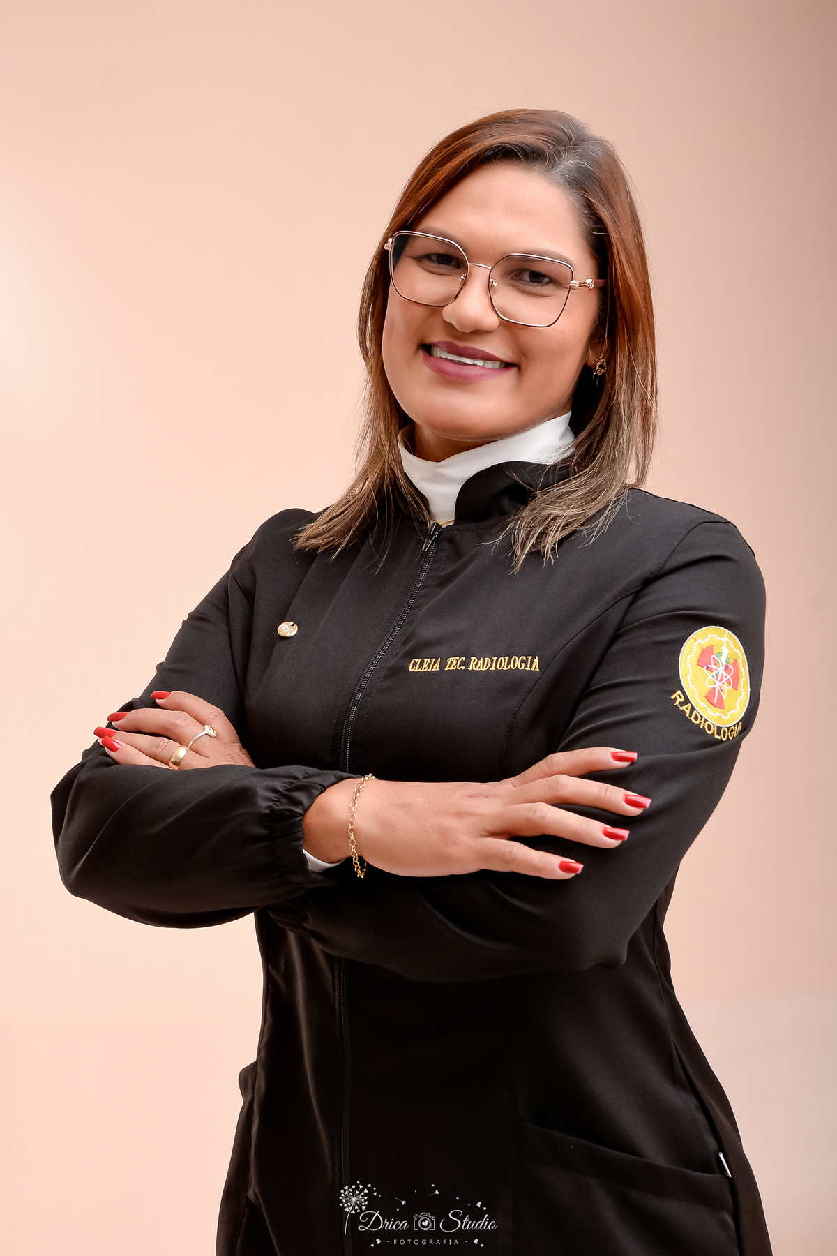 fotos formando - fotos em studio - radiologia - formatura - drica studio - formanda usando jaleco de radiologia - com os braços cruzados - sorrindo  
