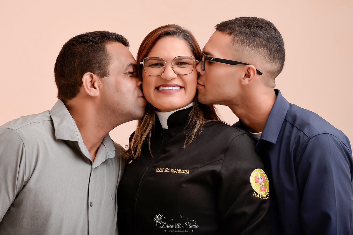 fotos formando - fotos em studio - radiologia - formatura - drica studio -familia - formanda usando jaleco de radiologia - pai e filho prestigiando a mãe - foto em fundo branco 